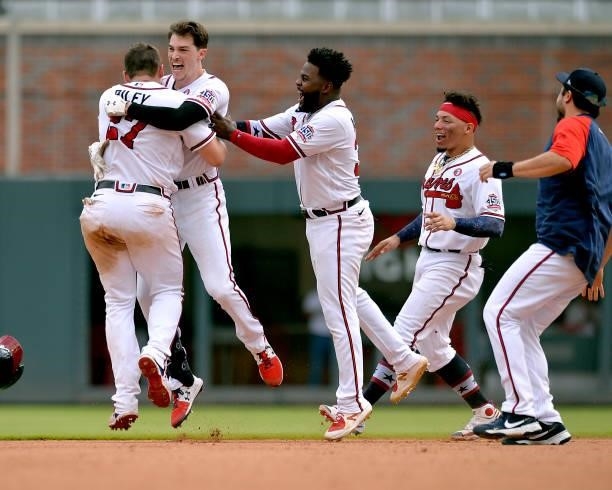 Austin Riley, Max Fried, Abraham Almonte, and William Contreras of the Atlanta Braves celebrate after winning against the Miami Marlins at Truist...