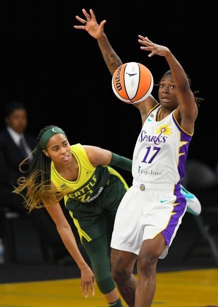 Jordin Canada of the Seattle Storm passes the ball around Erica Wheeler of the Los Angeles Sparks in the first half at Los Angeles Convention Center...