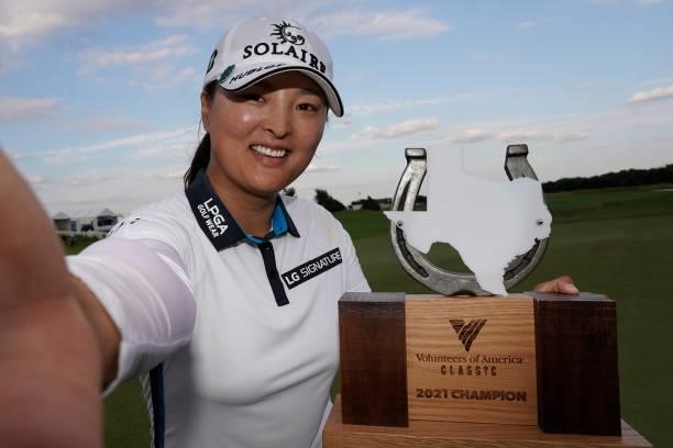 Jin Young Ko of Korea imitates a selfie as she poses with the trophy after winning the Volunteers of America Classic at the Old American Golf Club on...