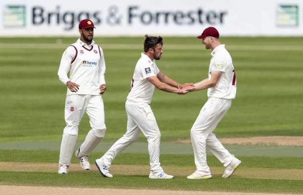 Simon Kerrigan of Northamptonshire celebrates with team mates Emilio Gay and Tom Taylor after taking the wicket of George Hill of Yorkshire during...
