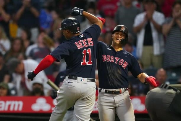 Rafael Devers of the Boston Red Sox celebrates with Enrique Hernández after Devers homered during the game between the Boston Red Sox and the Los...