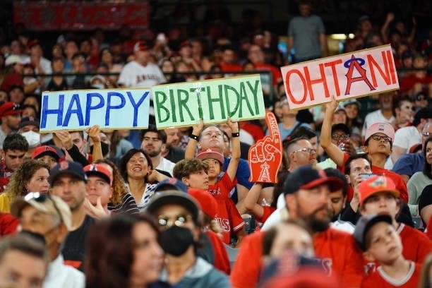 Fans hold signs wishing Shohei Ohtani of the Los Angeles Angels a happy birthday during the game between the Boston Red Sox and the Los Angeles...