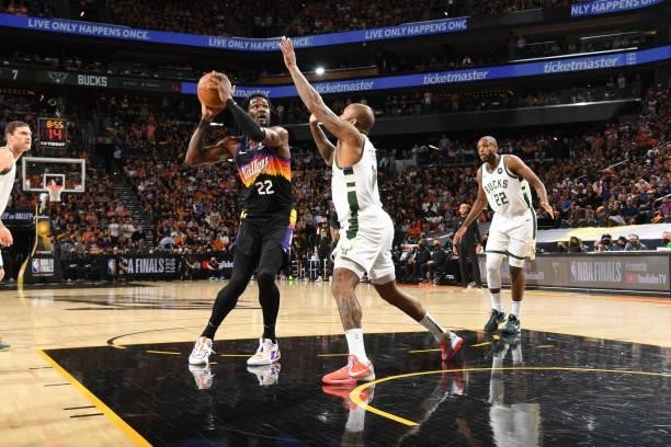 Deandre Ayton of the Phoenix Suns handles the ball as P.J. Tucker of the Milwaukee Bucks plays defense during Game One of the 2021 NBA Finals on July...