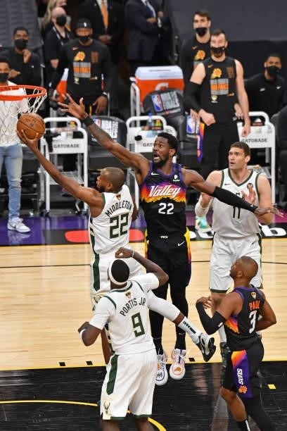 Khris Middleton of the Milwaukee Bucks drives to the basket around Deandre Ayton of the Phoenix Suns during Game One of the 2021 NBA Finals on July...