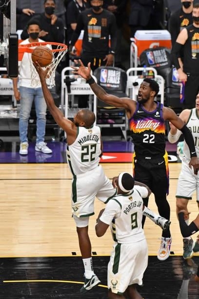 Khris Middleton of the Milwaukee Bucks drives to the basket around Deandre Ayton of the Phoenix Suns during Game One of the 2021 NBA Finals on July...