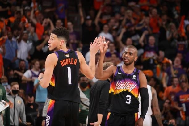 Devin Booker of the Phoenix Suns high fives Chris Paul of the Phoenix Suns during Game One of the 2021 NBA Finals on July 6, 2021 at Talking Stick...