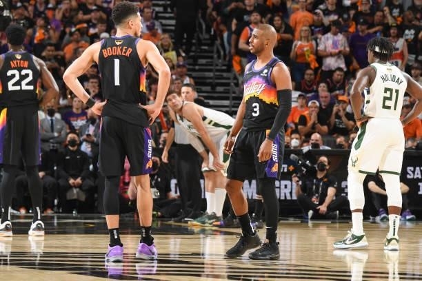 Devin Booker of the Phoenix Suns talks to Chris Paul of the Phoenix Suns during the game against the Milwaukee Bucks during Game One of the 2021 NBA...
