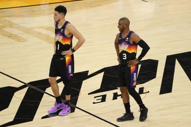 Chris Paul talks with Devin Booker of the Phoenix Suns during Game One of the 2021 NBA Finals on July 6, 2021 at Phoenix Suns Arena in Phoenix,...