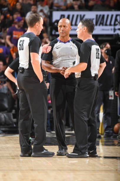 Referee Marc Davis talks to referee Josh Tiven and referee Pat Fraher during the game between the Milwaukee Bucks and Phoenix Suns during Game One of...