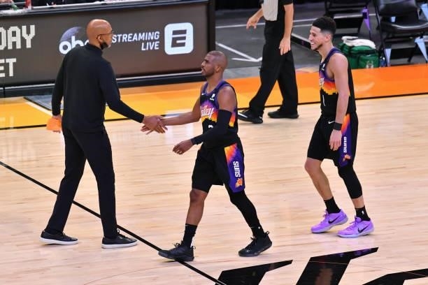 Monty Williams, Chris Paul and Devin Booker of the Phoenix Suns shake hands during Game One of the 2021 NBA Finals against the Milwaukee Bucks on...