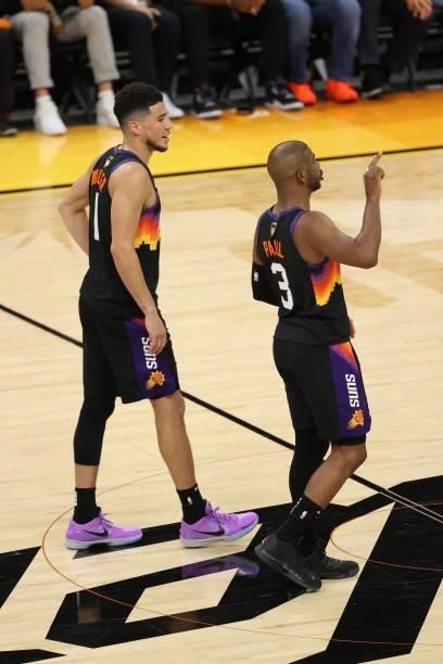 Devin Booker talks with Chris Paul of the Phoenix Suns during Game One of the 2021 NBA Finals on July 6, 2021 at Phoenix Suns Arena in Phoenix,...