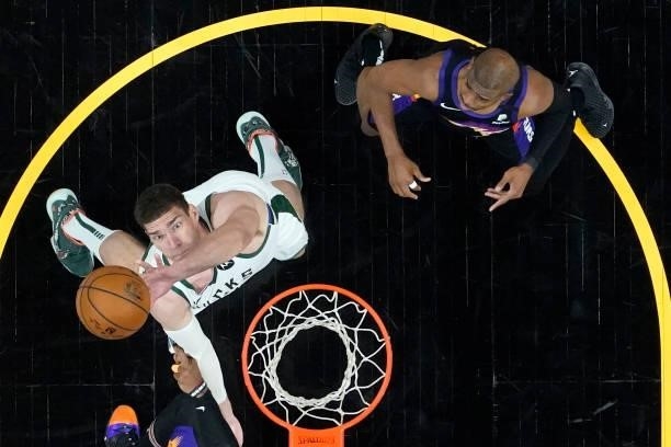 Milwaukee Bucks center Brook Lopez rebounds as Phoenix Suns guard Chris Paul, right, looks on during the first half in Game One of the NBA Finals at...