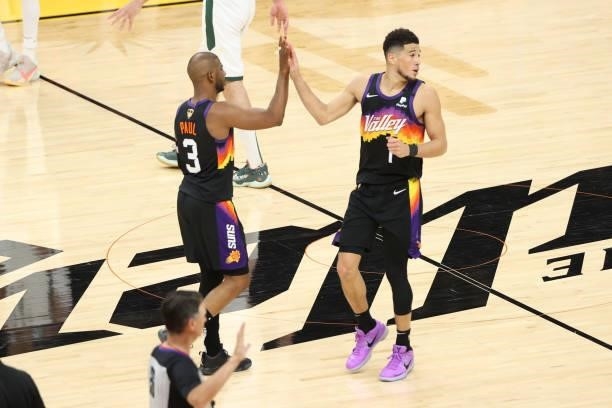 Devin Booker hi-fives Chris Paul of the Phoenix Suns during Game One of the 2021 NBA Finals on July 6, 2021 at Phoenix Suns Arena in Phoenix,...