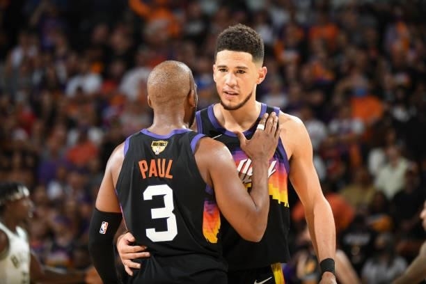 Chris Paul of the Phoenix Suns talks to Devin Booker of the Phoenix Suns during the game against the Milwaukee Bucks during Game One of the 2021 NBA...