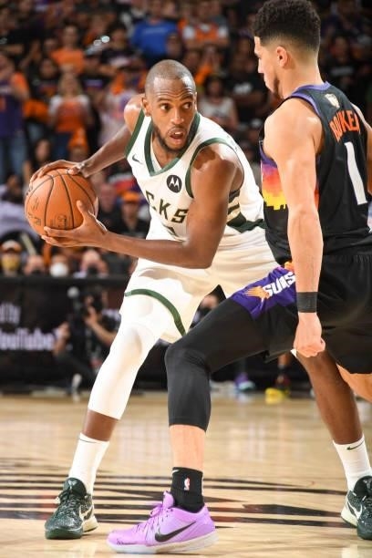 Khris Middleton of the Milwaukee Bucks handles the ball as Devin Booker of the Phoenix Suns plays defense during Game One of the 2021 NBA Finals on...