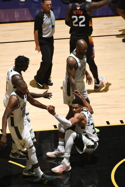 Khris Middleton and P.J. Tucker help up Giannis Antetokounmpo of the Milwaukee Bucks during Game One of the 2021 NBA Finals on July 6, 2021 at...