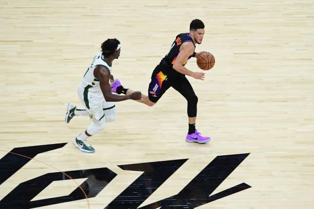 Devin Booker of the Phoenix Suns dribbles the ball around Jrue Holiday of the Milwaukee Bucks during Game One of the 2021 NBA Finals on July 6, 2021...