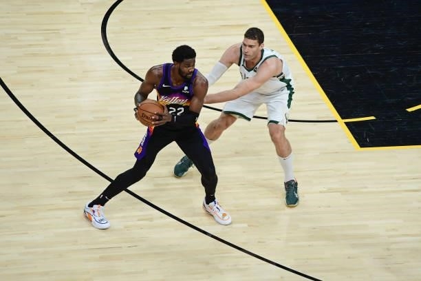 Deandre Ayton of the Phoenix Suns looks to pass the ball while Brook Lopez of the Milwaukee Bucks plays defense during Game One of the 2021 NBA...