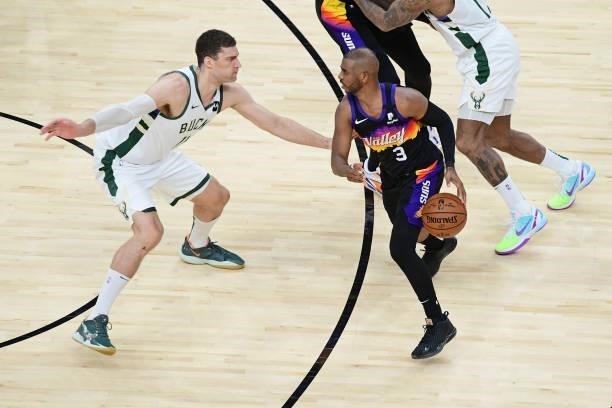 Chris Paul of the Phoenix Suns dribbles the ball while Brook Lopez of the Milwaukee Bucks plays defense during Game One of the 2021 NBA Finals on...