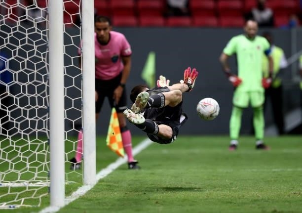 Goalkeeper Emiliano Martinez of Argentina dives to save a penalty kick by Yerry Mina of Colombia in a shootout during the semifinal match against...