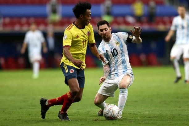 Juan Cuadrado of Colombia competes for the ball with Lionel Messi of Argentina during the Conmebol Copa America Brazil 2021 semi-final between...