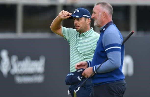 Francesco Molinari of Italy finishes his round at the 18th green with Ex footballer Alan McInally during a practice day prior to the abrdn Scottish...