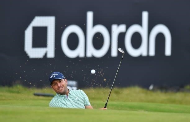 Francesco Molinari of Italy plays bunker shot at the 18th green during a practice day prior to the abrdn Scottish Open at The Renaissance Club on...