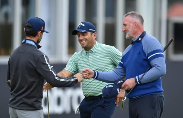 Francesco Molinari of Italy finishes his round at the 18th green with Ex footballer Alan McInally during a practice day prior to the abrdn Scottish...