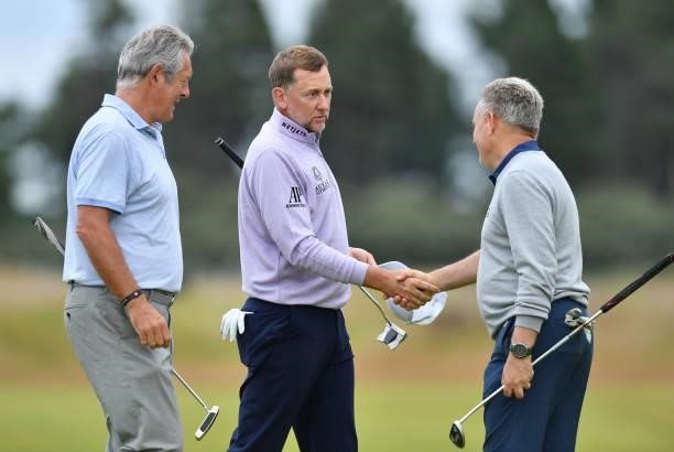 Ian Poulter of England finishes his round at the 18th hole with Ex Scotland rugby player Gavin Hasting , during a practice day prior to the abrdn...