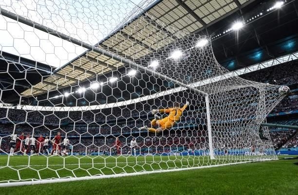 Denmark's forward Mikkel Damsgaard shoots and scores his team's first goal past England's goalkeeper Jordan Pickford during the UEFA EURO 2020...