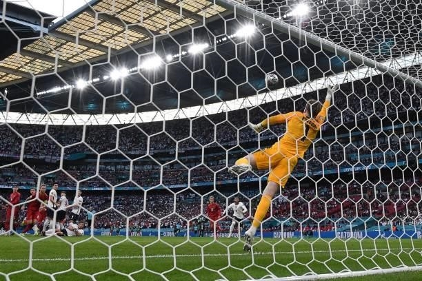 England's goalkeeper Jordan Pickford concedes a goal during the UEFA EURO 2020 semi-final football match between England and Denmark at Wembley...