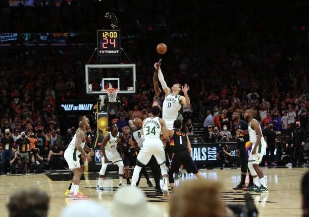 Brook Lopez of the Milwaukee Bucks jumps the opening tip against Deandre Ayton of the Phoenix Suns during Game One of the 2021 NBA Finals on July 6,...