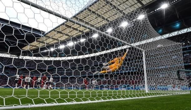 England's goalkeeper Jordan Pickford concedes a goal during the UEFA EURO 2020 semi-final football match between England and Denmark at Wembley...