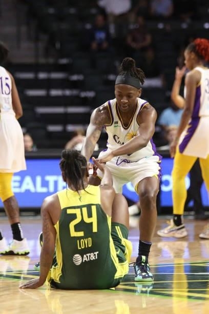 Erica Wheeler of the Los Angeles Sparks helps up Jewell Loyd of the Seattle Storm during the game on July 7, 2021 at the Angel of the Winds Arena, in...