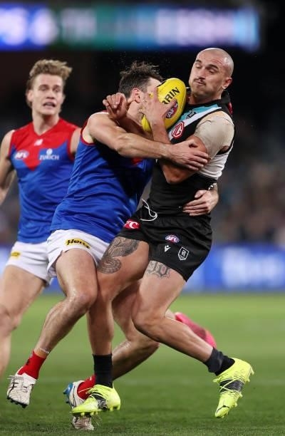 Sam Powell-Pepper of the Power is tackled by Michael Hibberd of the Demons during the 2021 AFL Round 17 match between the Port Adelaide Power and the...