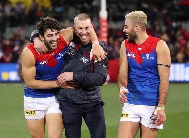 Christian Petracca of the Demons hugs coach Simon Goodwin with Christian Salem laughing after the win during the 2021 AFL Round 17 match between the...