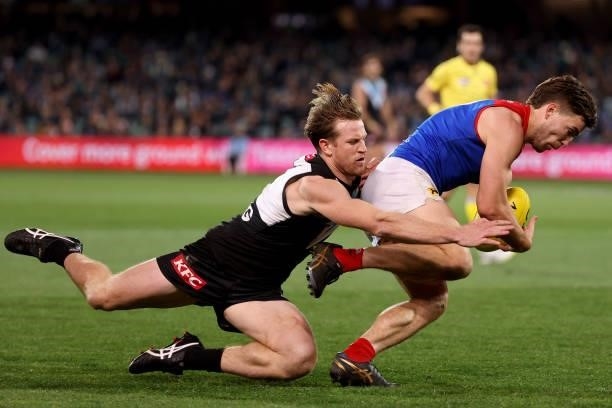 Tom Jonas of the Power tackles Jack Viney of the Demons during the 2021 AFL Round 17 match between the Port Adelaide Power and the Melbourne Demons...