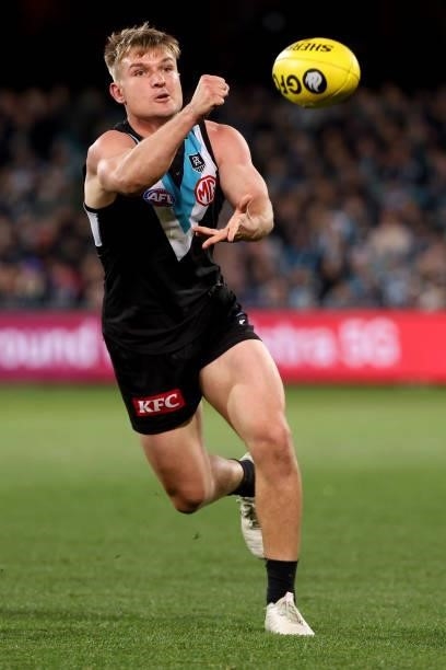 Ollie Wines of the Power handpasses the ball during the 2021 AFL Round 17 match between the Port Adelaide Power and the Melbourne Demons at Adelaide...