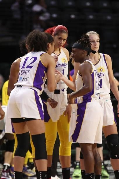 Amanda Zahui B hi-fives Nia Coffey and Erica Wheeler of the Los Angeles Sparks during the game against the Seattle Storm on July 7, 2021 at the Angel...