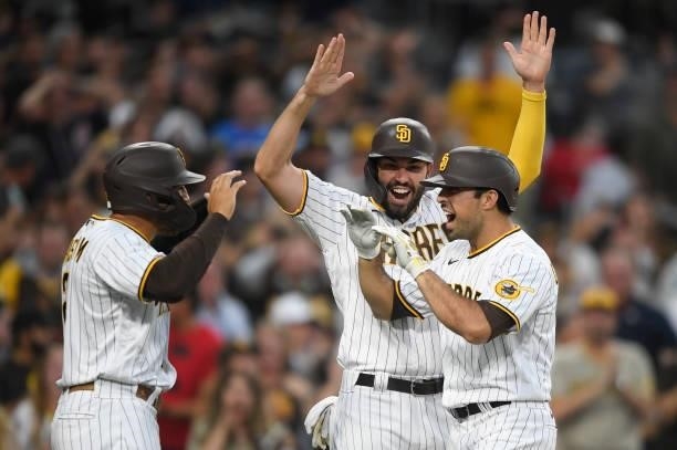 Daniel Camerena of the San Diego Padres, right, is congratulated by Eric Hosmer and Trent Grisham after hitting a grand slam home run during the...