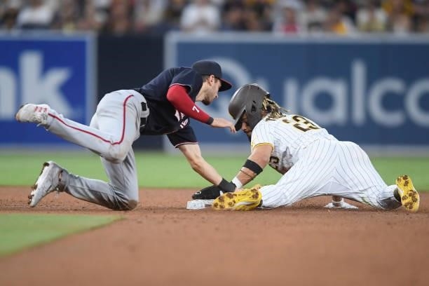Fernando Tatis Jr. #23 of the San Diego Padres steals second base ahead of the tag of Trea Turner of the Washington Nationals during the fourth...
