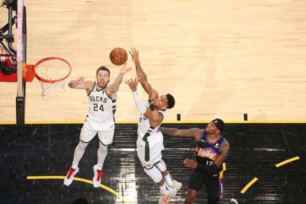 Pat Connaughton of the Milwaukee Bucks and Giannis Antetokounmpo of the Milwaukee Bucks rebound the ball against the Phoenix Suns during Game Two of...