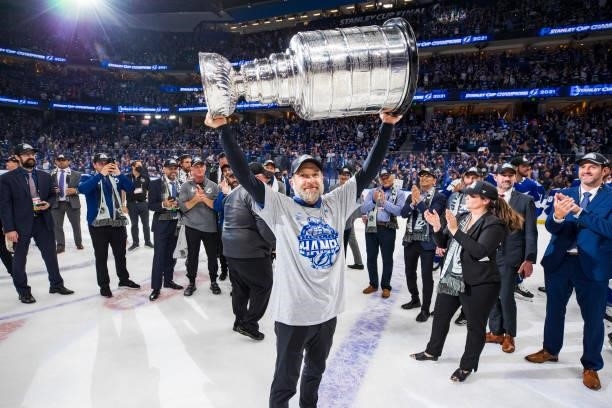Assistant Athletic Trainer, Mike Poirier of the Tampa Bay Lightning hoists the Stanley Cup overhead after the Tampa Bay Lightning defeated the...