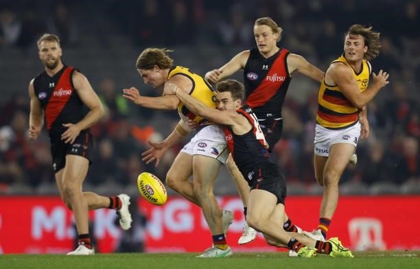 Sam Berry of the Crows is tackled by Will Snelling of the Bombers during the 2021 AFL Round 17 match between the Essendon Bombers and the Adelaide...