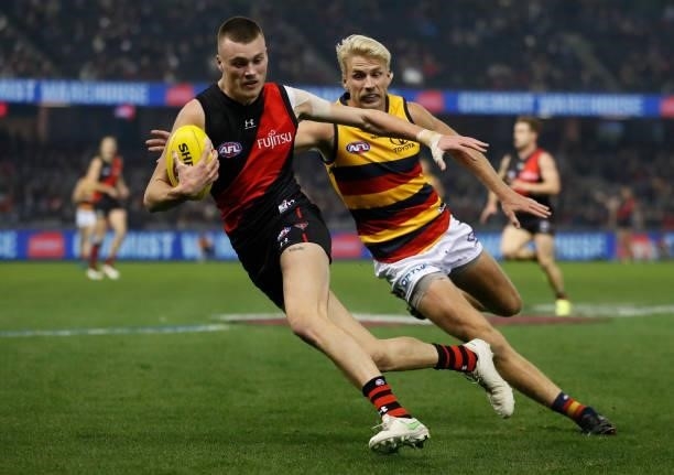 Nikolas Cox of the Bombers evades Billy Frampton of the Crows during the 2021 AFL Round 17 match between the Essendon Bombers and the Adelaide Crows...