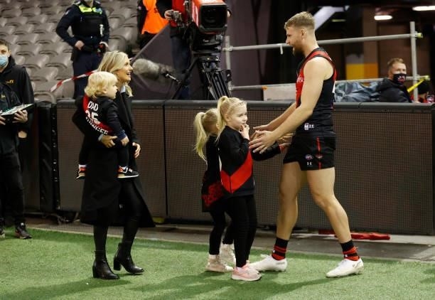 Jake Stringer of the Bombers greets partner Taylor McVeigh and children before his 150th match during the 2021 AFL Round 17 match between the...