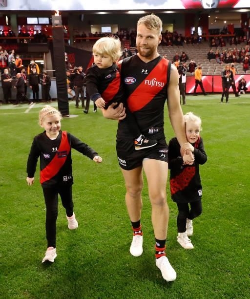 Jake Stringer of the Bombers runs onto the field with his children before his 150th match during the 2021 AFL Round 17 match between the Essendon...