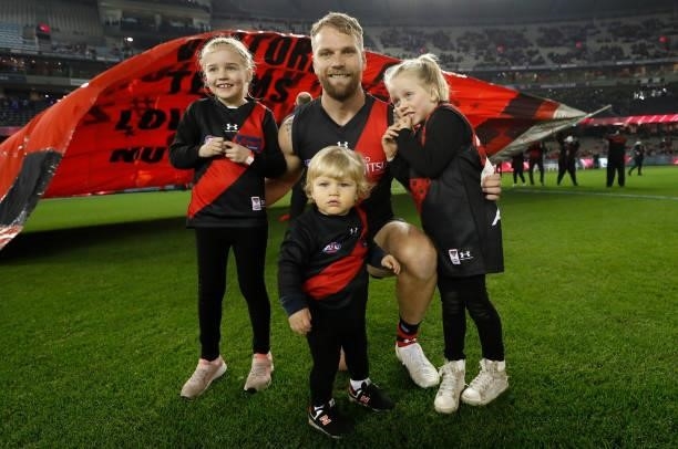 Jake Stringer of the Bombers poses for a photograph with his children before his 150th match during the 2021 AFL Round 17 match between the Essendon...