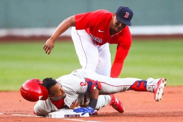 Jean Segura of the Philadelphia Phillies slides safely into third base under the tag of Rafael Devers of the Boston Red Sox after hitting a triple in...