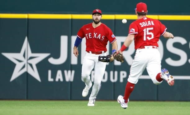 Joey Gallo of the Texas Rangers and teammate Nick Solak field a single off the bat of Sean Murphy of the Oakland Athletics during the second inning...